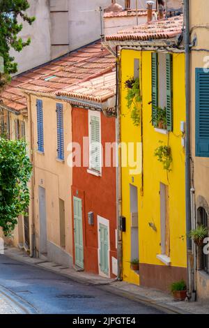 Facciate colorate di antiche case in una strada nel centro storico di Hyères, in Francia, nel dipartimento francese del Var Foto Stock