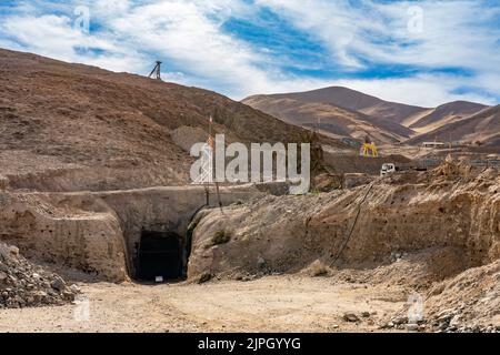 Antica struttura in legno e originale ingresso sotterraneo presso il sito dell'incidente della miniera di San Jose del 2010 vicino a Copiapo, Cile. Il telaio di sollevamento giallo al n. 3 wa Foto Stock