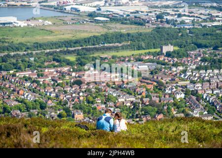 Una coppia seduta a Cave Hill ammirando la vista di Belfast in Irlanda del Nord, Regno Unito Foto Stock