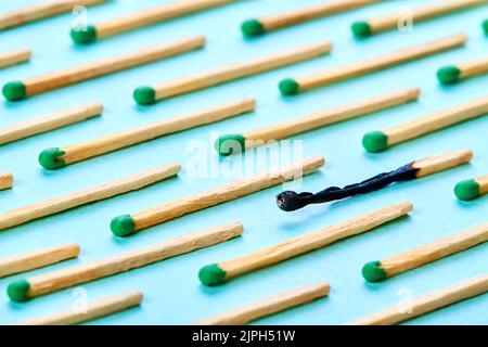 Sfondo di tutto sparso fuori partite e uno bruciato su una superficie blu come un concetto di sindrome di burnout Foto Stock