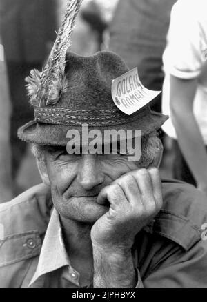 Bucarest, Romania, aprile 1990. 'Golaniada', una grande protesta anti-comunismo in Piazza dell'Università dopo la Rivoluzione rumena del 1989. La gente si riunirebbe ogni giorno per protestare contro gli ex comunisti che hanno preso il potere dopo la Rivoluzione. Come il presidente Iliescu li chiamò 'golani' (hooligan), i manifestanti adottarono con orgoglio il termine e lo portarono come un distintivo. Questo paese anziano indossa un tag che dice "hooligan rumeno”. Foto Stock