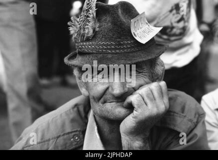 Bucarest, Romania, aprile 1990. 'Golaniada', una grande protesta anti-comunismo in Piazza dell'Università dopo la Rivoluzione rumena del 1989. La gente si riunirebbe ogni giorno per protestare contro gli ex comunisti che hanno preso il potere dopo la Rivoluzione. Come il presidente Iliescu li chiamò 'golani' (hooligan), i manifestanti adottarono con orgoglio il termine e lo portarono come un distintivo. Questo paese anziano indossa un tag che dice "hooligan rumeno”. Foto Stock