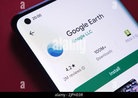 App google Earth visualizzata in Google Play Store sullo schermo dello smartphone su sfondo rosso. Foto ravvicinata con messa a fuoco selettiva. Stafford, Ki Foto Stock