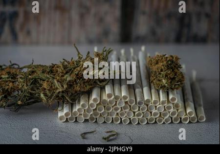 Giunti in carta marijuana su pavimento in cemento con fondo in legno Foto Stock