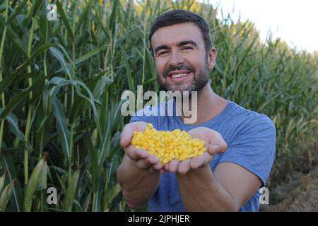 Coltivatore in campi di mais bei che mostrano prodotto organico Foto Stock