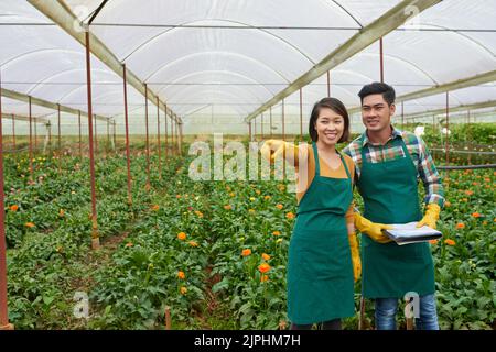 Giovane coppia vietnamita che lavora in serra di fiori Foto Stock