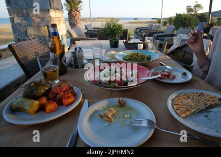 Delizioso cibo greco in un ristorante di fronte alla spiaggia di Manganari in Grecia iOS Foto Stock