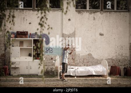 Bilje, Croazia. 18th ago, 2022. Un ragazzo è visto mentre gioca con le lampadine alla Slama (paglia) Land Art Festival che si svolge a Kozjak Pudara insediamento a Bilje, Baranja Regione, Croazia il 18 agosto 2022. Lo Slama Land Art Festival è un evento annuale organizzato dallo scultore accademico Nikola Faller. Il tema di quest'anno dello Slama Land Art Festival 2022 è opera del grande inventore Nikola Tesla, nato e vissuto in Croazia in giovane età. Photo: Dubravka Petric/PIXSELL Credit: Pixsell photo & video agency/Alamy Live News Foto Stock