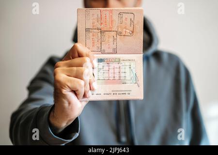 Passaporto straniero russo nelle mani di un uomo. Divieto di visto Schengen per i turisti russi di viaggiare verso l'Unione europea. Foto di alta qualità Foto Stock