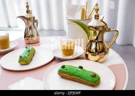 Pistacchio eclair e caffè arabo presso lo Specialist Middle Eastern Bafarat Cafe di Soho, Londra, Regno Unito Foto Stock