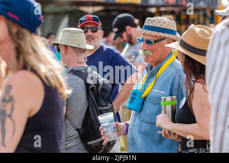 NEW ORLEANS, LA, USA - 30 MARZO 2019: Baby boomer con baffi verdi focalizzato selettivamente tra la folla in un festival all'aperto Foto Stock