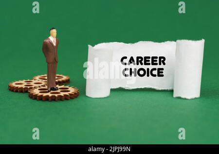 Concetto aziendale. La figura di un uomo è in piedi sugli ingranaggi e legge l'iscrizione - SCELTA DI CARRIERA su carta Foto Stock