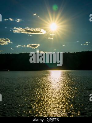 Yonkers, NY - 13 agosto 2022 Vista verticale del tramonto che si riflette sul fiume Hudson, visto dal lungomare di Yonkers. Foto Stock