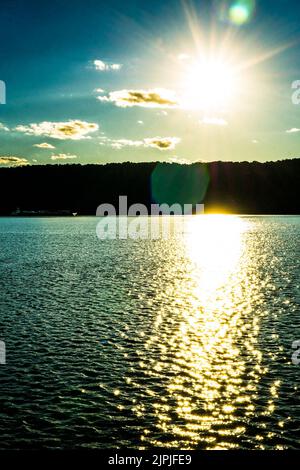 Yonkers, NY - 13 agosto 2022 Vista verticale del tramonto che si riflette sul fiume Hudson, visto dal lungomare di Yonkers. Foto Stock