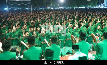 Mass dance and chanting of prayers accompanied by tambourine music from the Ishari group in the town square of Jombang Stock Photo