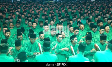 Danza di massa e canto di preghiere accompagnati da musica tamburina del gruppo Ishari nella piazza della città di Jombang Foto Stock