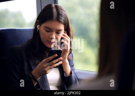 giovane donna, in movimento, cuffie, smartphone, treno, ascoltare musica, ragazza, ragazze, donna, giovani donne, in movimento, auricolari, auricolari, Foto Stock