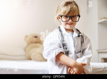 Un giorno Ill salva le vite appena come mommy fa. Ritratto di una adorabile bambina vestita da medico. Foto Stock