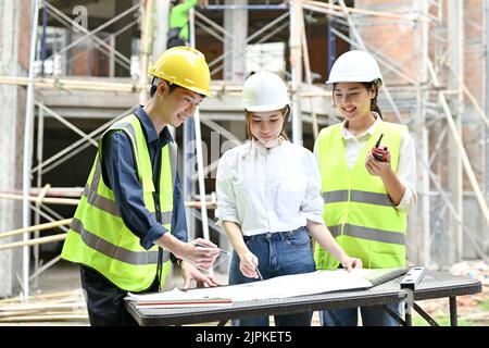 Un team di ingegneri civili sta lavorando e ispezionando l'edificio insieme nel cantiere. Foto Stock