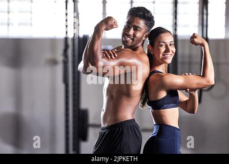 Fitness, muscoli flessionanti e forti obiettivi di coppia mentre fare esercizio fisico o di allenamento in palestra. Ritratto di persone sportive in forma, donna o uomo che si mostra Foto Stock