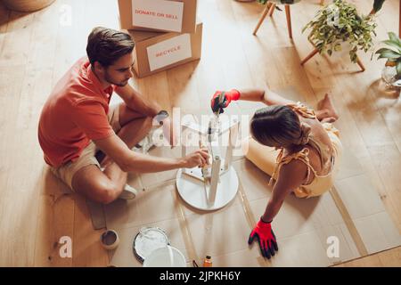 Riciclare, prosperare mobili e pittore coppia pittura tavolo in legno per un nuovo progetto creativo in un appartamento. Vista dall'alto dell'uomo e della donna che lavorano Foto Stock