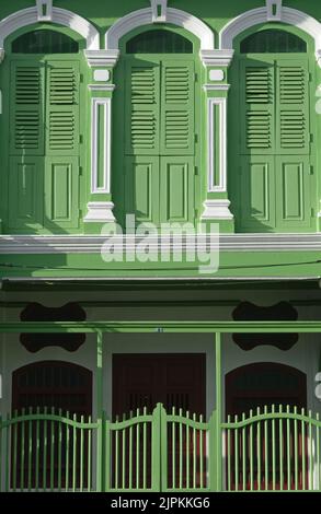 Finestre ad arco e a graticcio su una colorata casa tradizionale sino-portoghese in Thalang Road nella zona della Città Vecchia di Phuket, Phuket, Thailandia Foto Stock