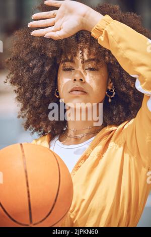 Serio giocatore di basket che gioca a palla per allenarsi, fare esercizio di benessere e allenamento sportivo in campo. Attiva donna nera esercizio Foto Stock