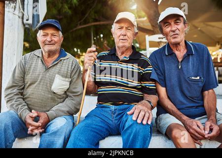 I tre migliori amici che chiunque può avere. Ritratto di un gruppo di uomini allegri anziani seduti insieme mentre si guarda nella fotocamera all'esterno. Foto Stock