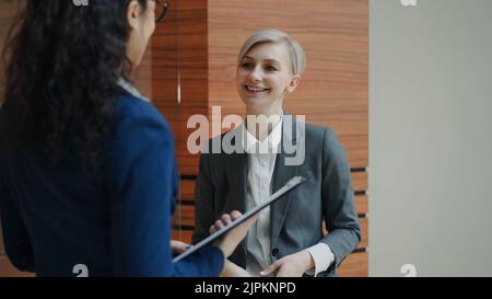 Due donne d'affari colleghi che parlano in un ufficio moderno al coperto Foto Stock