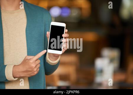 Immagine ritagliata dell'uomo che punta lo smartphone nelle sue mani Foto Stock