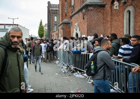 Lembeke, Belgio. 19th ago, 2022. L'immagine mostra decine di richiedenti asilo in attesa all'ingresso del centro di registrazione Fedasil Klein Kasteeltje - Petit Chateau a Bruxelles, venerdì 19 agosto 2022. FOTO DI BELGA JAMES ARTHUR GEKIERE Credit: Belga News Agency/Alamy Live News Foto Stock