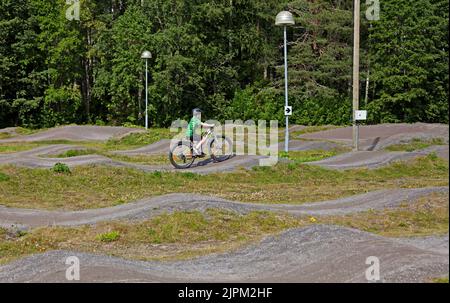 Umea, Norrland Svezia - 18 luglio 2022: Un ragazzo guida una bicicletta sulla pista di pompaggio Foto Stock
