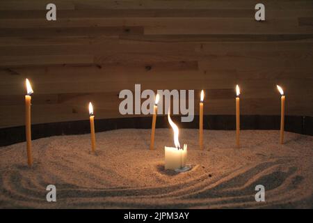 Ero in una chiesa e ho visto queste candele. Stavano in piedi lì a guardare la candela di mezzo danzare. Ho pensato che fosse molto interessante e caldo. Foto Stock