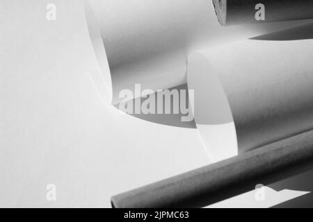 Spazio di lavoro minimo con rotoli di carta, fogli di carta bianca per progetti, disegni. Business Copy Space Mockup. Foto Stock