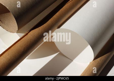 Rotoli di carta marrone su sfondo bianco. Studio di design moderno Mockup. Modello BluePrint. Foto Stock