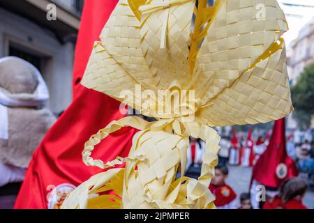 Particolare di una palma fatta a Elche, Spagna, portata da un Nazareno e penitente, nella Domenica delle Palme, durante la settimana Santa, nella processione la Borriquita Foto Stock