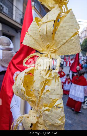 Particolare di una palma fatta a Elche, Spagna, portata da un Nazareno e penitente, nella Domenica delle Palme, durante la settimana Santa, nella processione la Borriquita Foto Stock