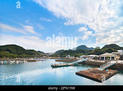 kyushu, giappone - 09 2021 dicembre: Pontile del Kujukushima Pearl Sea Resort circondato da montagne dopo la partenza della barca da crociera ca Foto Stock