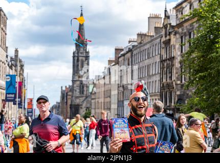 Edimburgo, Scozia, Regno Unito, 19th agosto 2022. Artisti fringe sul Royal Mile: La strada è piena di fringe-goers, artisti di strada e cast di spettacoli che distribuiscono volantini in una giornata di sole. Nella foto: Un circo performer da Lost in Translation Hotel Paradiso spettacolo circo. Credit: Sally Anderson/Alamy Live News Foto Stock