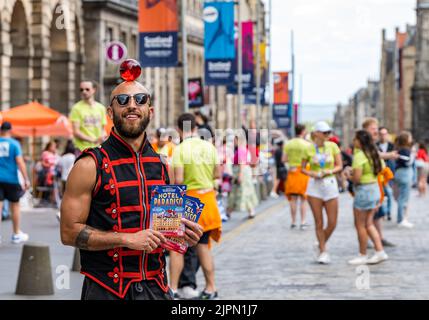 Edimburgo, Scozia, Regno Unito, 19th agosto 2022. Artisti fringe sul Royal Mile: La strada è piena di fringe-goers, artisti di strada e cast di spettacoli che distribuiscono volantini in una giornata di sole. Nella foto: Un circo performer da Lost in Translation Hotel Paradiso spettacolo circo. Credit: Sally Anderson/Alamy Live News Foto Stock