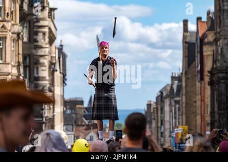 Edimburgo, Scozia, Regno Unito, 19th agosto 2022. Fringe Performers on the Royal Mile: La strada è piena di fringe-goers, artisti di strada in una giornata di sole. Nella foto: Un giocoliere di spada. Intrattiene la folla credito: Sally Anderson/Alamy Live News Foto Stock