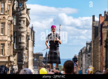 Edimburgo, Scozia, Regno Unito, 19th agosto 2022. Fringe Performers on the Royal Mile: La strada è piena di fringe-goers, artisti di strada in una giornata di sole. Nella foto: Un giocoliere di spada. Intrattiene la folla credito: Sally Anderson/Alamy Live News Foto Stock