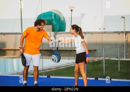 Due giocatori di padel si salutano a vicenda facendo il pugno - gli amici di Padel salutano al momento del covid Foto Stock