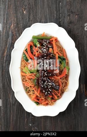 Japchae, piatto di noodle coreano CHAP Chae con taglio Bulgogi di manzo, vista dall'alto Foto Stock