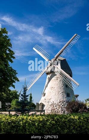 Mulino a vento di tipo olandese ad Araisi, Lettonia. Giorno estivo di sole. Stile della vecchia Europa. Cielo blu. Erba verde. Foto Stock