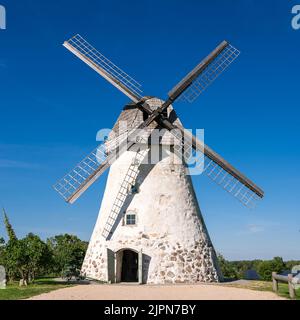 Mulino a vento di tipo olandese ad Araisi, Lettonia. Giorno estivo di sole. Stile della vecchia Europa. Cielo blu. Erba verde. Foto Stock