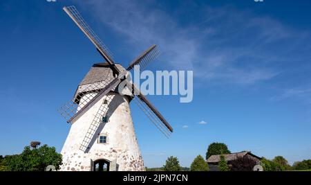 Mulino a vento di tipo olandese ad Araisi, Lettonia. Giorno estivo di sole. Stile della vecchia Europa. Cielo blu. Erba verde. Foto Stock