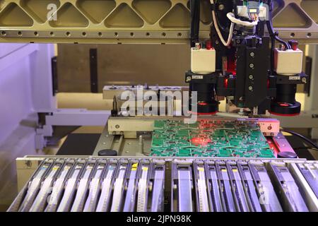 Installatore di parti SMD su schede e parti di saldatura. Macchina per il montaggio e la saldatura automatici di schede elettroniche. Saldatura elettrica Foto Stock