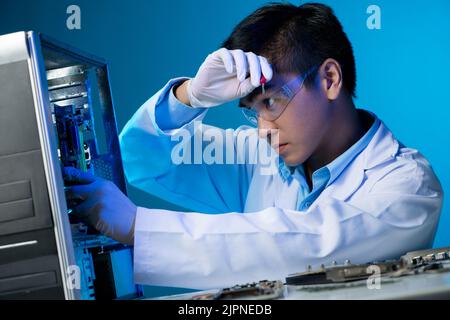 Ingegnere elettronico vietnamita che monta il personal computer Foto Stock