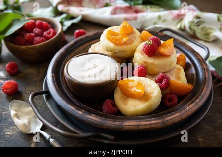 Colazione sana e deliziosa. Casetta casereccia frittelle senza glutine (sciroppi, frittelle cagliate) con bacche su legno rustico backgroun Foto Stock